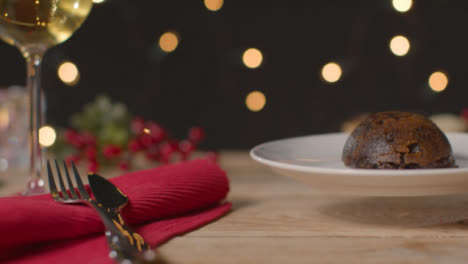 Sliding-Shot-of-Christmas-Pudding-Being-Placed-On-Table