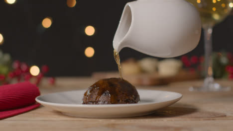 Sliding-Shot-of-Christmas-Pudding-Being-Lit-with-Alcohol-and-Match