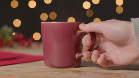 Sliding-Shot-of-Hot-Drink-Mug-Being-Placed-On-Festively-Decorated-Table