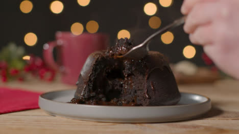 Close-Up-Shot-of-Hand-Using-Fork-to-Take-Piece-of-Christmas-Chocolate-Cake