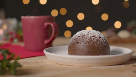 Tracking-Shot-Pulling-Away-from-Christmas-Pudding-On-Rustic-Table