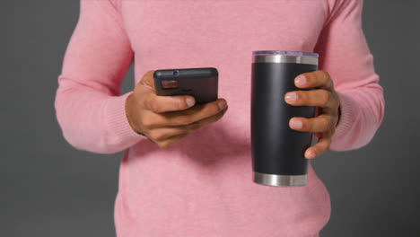 Close-Up-Shot-of-Man-Texting-and-Drinking-From-Flask
