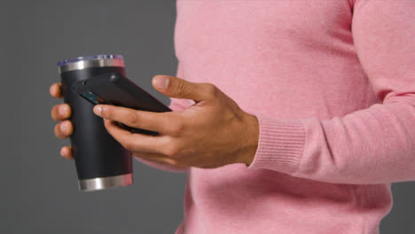 Close-Up-Shot-of-Man-Drinking-From-Flask-and-Texting