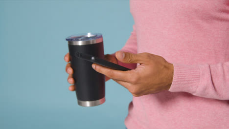 Close-Up-Shot-of-a-Man-Texting-and-Drinking-From-a-Flask