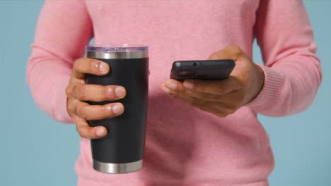 Close-Up-Shot-of-Young-Adult-Man-Texting-and-Drinking-From-Flask
