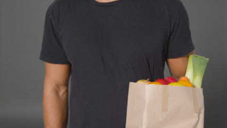 Close-Up-Shot-of-Man-Holding-Paper-Bag-of-Fruit-and-Vegetables