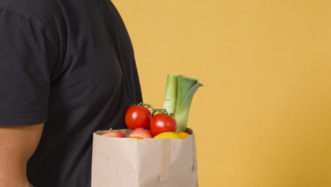 Close-Up-Side-Shot-of-Man-Walking-Away-with-Bag-of-Fruit-and-Vegetables