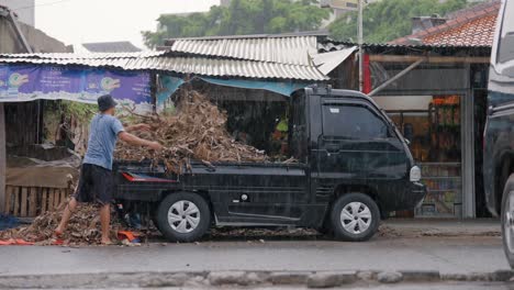 Wide-Shot-of-Workers-Unloading-Bananas-from-a-Van-In-the-Rain