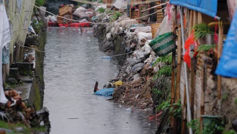 Lange-Einstellung-Des-Regens,-Der-In-Einen-Fluss-Der-Stadt-Jakarta-Strömt
