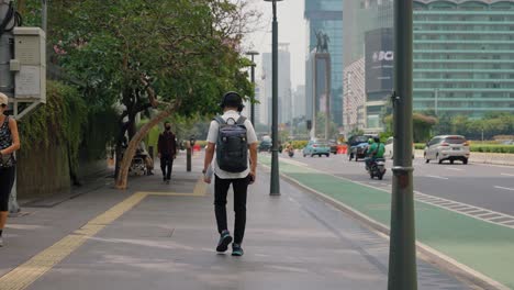 Kamerafahrt,-Die-Einer-Person-Folgt,-Die-Eine-Straße-In-Jakarta-Hinuntergeht