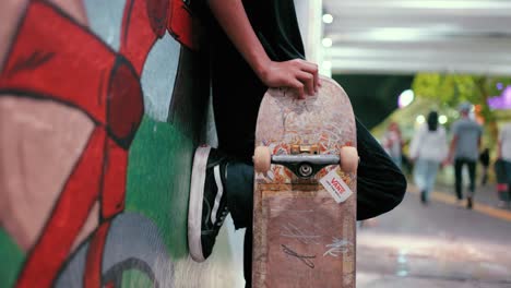 Close-Up-Shot-of-Boy-Stood-with-Skateboard-in-Jakarta
