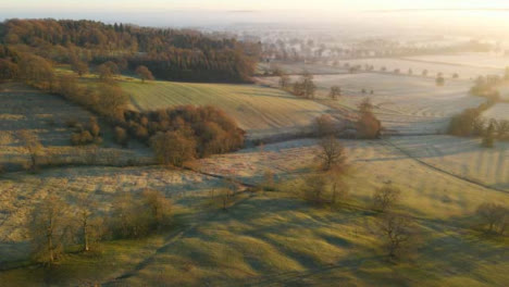 Drohnenaufnahme-Einer-Riesigen-Nebligen-Ländlichen-Landschaft-Bei-Sonnenaufgang