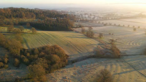 Drohnenaufnahme-Einer-Riesigen-Nebligen-Ländlichen-Landschaft-Bei-Sonnenaufgang