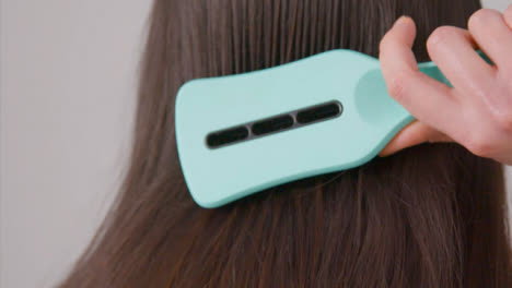 Close-Up-Back-Shot-of-a-Woman-Brushing-Her-Hair
