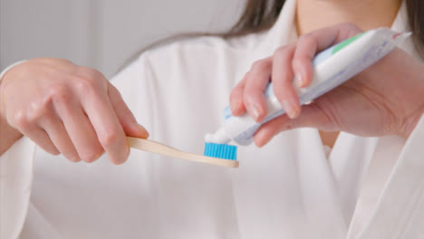Close-up-Shot-of-a-Woman-Applying-Toothpaste-to-Brush