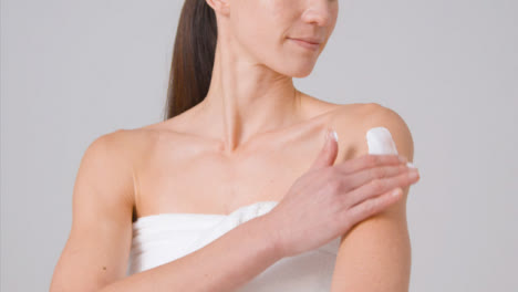 Mid-Shot-of-Woman-Applying-Cream-to-Arms
