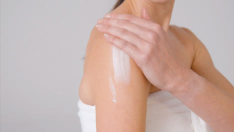 Close-Up-Shot-of-Woman-Applying-Cream-to-Arms