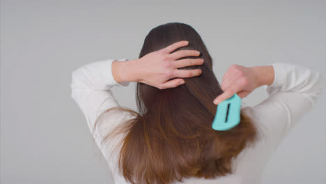 Mid-Shot-of-Woman-Brushing-Hair