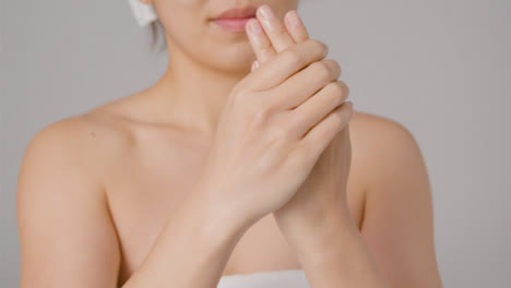 Close-Up-Shot-of-Young-Woman-Rubbing-Cream-into-Hands