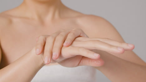 Close-Up-Shot-of-a-Woman-Rubbing-Cream-into-Hands