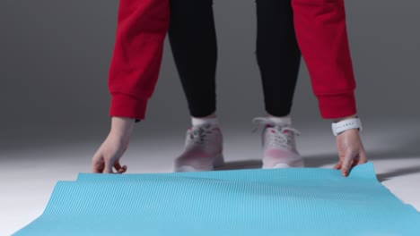 Mid-Shot-of-Girl-Rolling-Out-Yoga-Mat