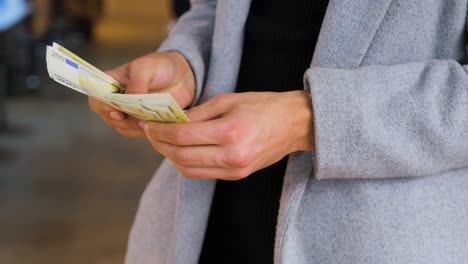 Close-Up-Shot-of-Man-Counting-His-Money