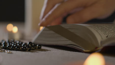 Tracking-Shot-of-Burning-Candles-Around-Holy-Bible-and-a-Crucifix