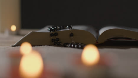 Tiro-De-Seguimiento-De-Velas-Encendidas-Alrededor-De-La-Biblia-Y-El-Crucifijo-12