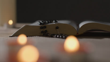 Mid-Shot-of-Candles-Lit-around-Bible-and-Crucifix