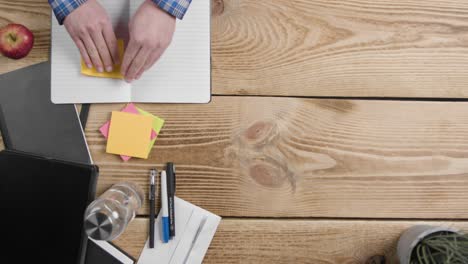 Overhead-Shot-of-Man-Writing-on-Sticky-Notes