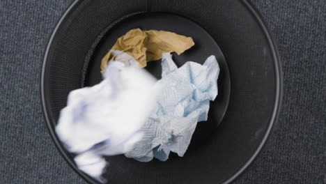 Top-Down-Shot-of-Rubbish-Being-Thrown-into-Rotating-Bin