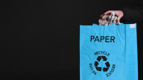 Mittlere-Aufnahme-Von-Papier,-Das-In-Den-Recyclingbeutel-Gelegt-Wird