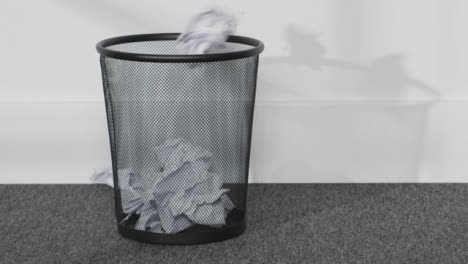Close-Up-Shot-of-Paper-Being-Thrown-into-a-Bin