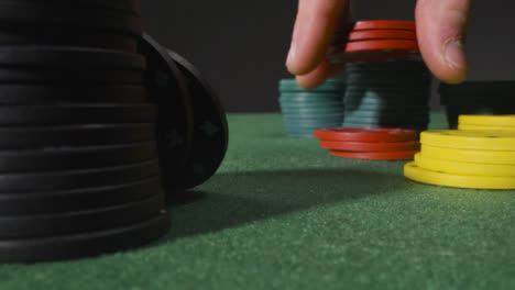 Close-Up-of-Someone-Putting-Tokens-Into-Piles