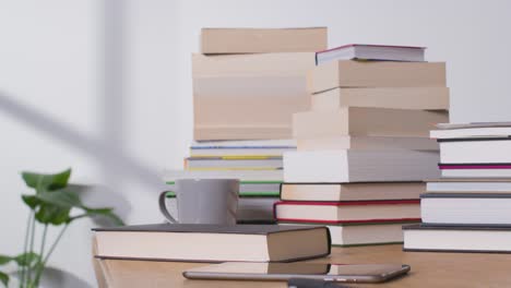 Stop-Motion-Shot-of-Multiple-Stacks-of-Books-On-Desk