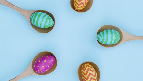 Top-Down-Shot-of-Rotating-Easter-Eggs-In-Wooden-Spoons
