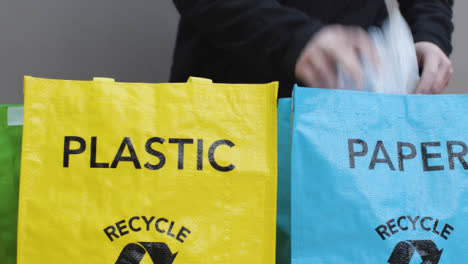 Tracking-Shot-of-Person-Placing-Mixed-Rubbish-into-Recycling-Bags