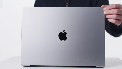 Close-Up-Shot-of-Person-Opening-a-Brand-New-MacBook-Pro-