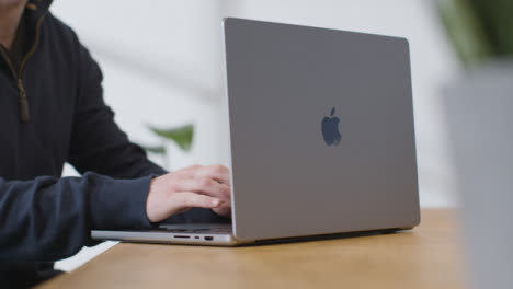 Sliding-Shot-of-Person-Working-On-Brand-New-MacBook-Pro-at-Desk-01