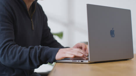 Medium-Shot-of-Person-Working-On-Brand-New-MacBook-Pro-at-Desk-01