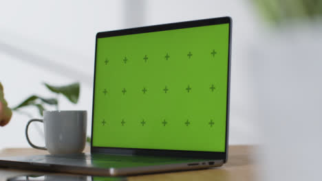 Sliding-Shot-of-Brand-New-MacBook-Pro-On-Desk-with-Green-Screen-04