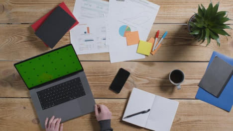 Top-Down-Shot-of-Person-Working-at-Desk-with-Green-Screen-Apple-MacBook-Pro-02