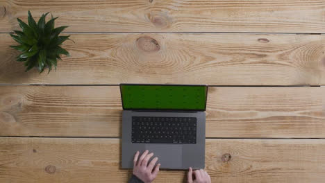 Top-Down-Shot-of-Person-Working-at-Desk-with-Green-Screen-Apple-MacBook-Pro-06