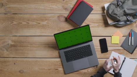 Top-Down-Shot-of-Person-Working-at-Desk-with-Green-Screen-Apple-MacBook-Pro-06