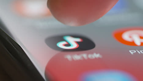 Close-Up-of-Finger-Pressing-Tik-Tok-App-on-Mobile-Phone