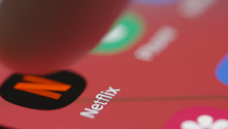 Extreme-Close-Up-Tracking-Shot-of-Finger-Pressing-Netflix-App-on-Phone