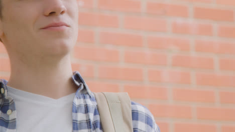 Close-Up-Shot-of-a-Young-Man-In-Front-of-Brick-Wall