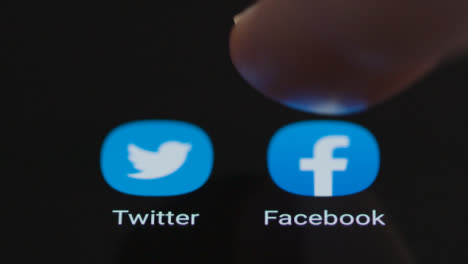 Primer-Plano-De-Un-Dedo-Tocando-La-Aplicación-De-Facebook-En-La-Pantalla-De-Un-Smartphone