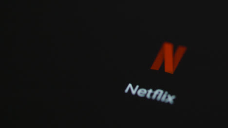 Primer-Plano-De-Un-Dedo-Tocando-Netflix-En-La-Pantalla-De-Un-Teléfono-Inteligente