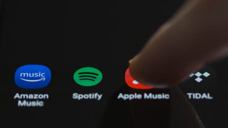 Close-Up-Shot-of-Finger-Tapping-Apple-Music-On-a-Smartphone-Touch-Screen